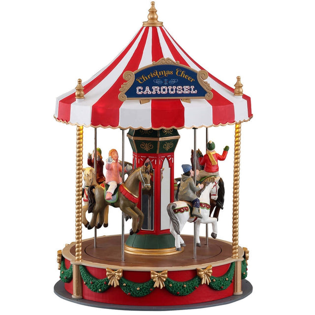 Polyresin figure for a Lemax display. Designed to look like a Christmas themed carousel. The top of the carousel is a red and white umbrella. The carousel features lots of gold and green accents There are kids on every horse on the carousel. The sign on the top reads "Christmas Cheer Carousel."
