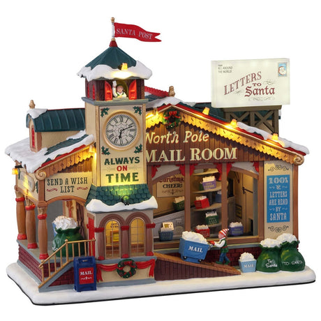 Polyresin lighted building for Lemax display. Designed to look like a wooden post office. There's a red flag on top of the roof that reads "Santa Post." There's a big sign that's shaped like an envelope that reads "Letters to Santa." There's a big clock and it reads "Always on time" underneath. Next to the clock it reads "North Pole Mail Room." There's an elf pushing a big cart of mail.
