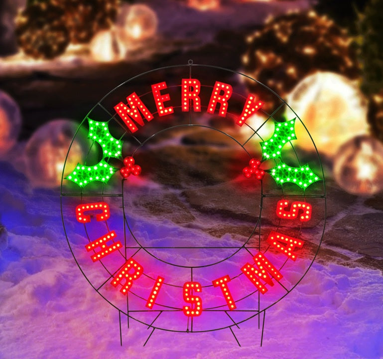 Outdoor LED decoration that reads "Merry Christmas." The text is red. There are green holly leaves and red berries.