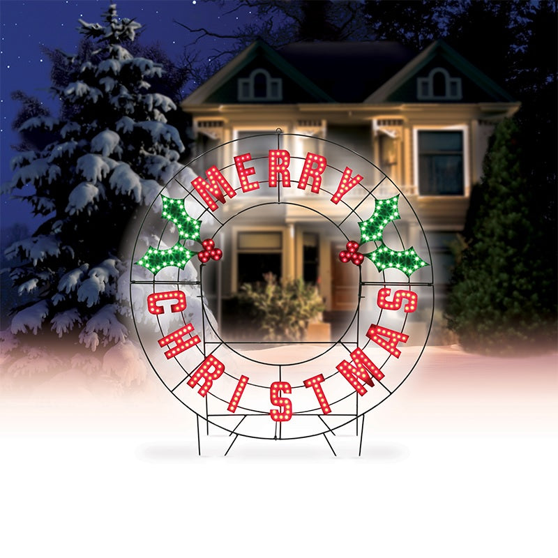 Outdoor LED decoration that reads "Merry Christmas." The text is red. There are green holly leaves and red berries.