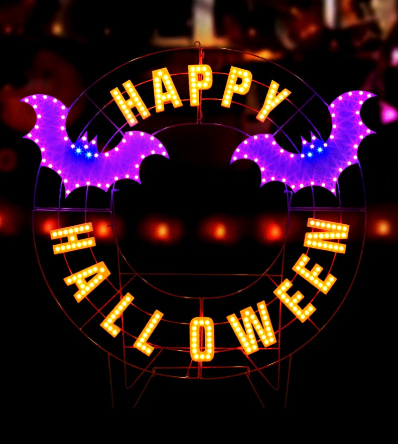 LED Halloween decoration pre-lit with warm white and purple lights. Wire is shaped like a wreath and reads "HAPPY HALLOWEEN" and features two purple bats.