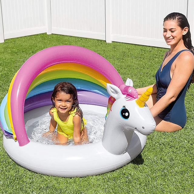 Inflatable pool for kids. The bottom is white and has a unicorn head. There's a slight cover on the pool that is pink, orange, lime green, blue and purple.