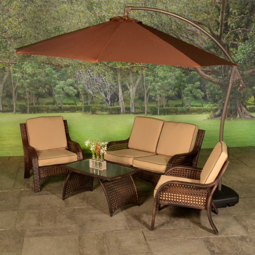 Patio furniture set on a stone patio. The frames are dark brown and the cushions are an orange-ish, tan color.