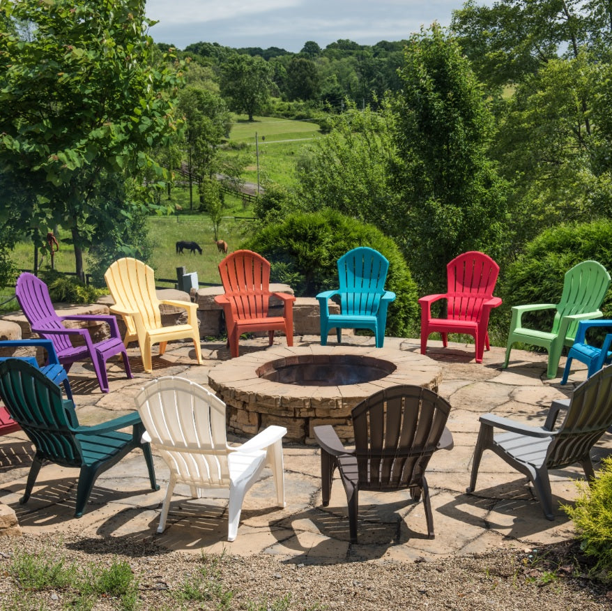 Different colored Adirondack chairs around a fire pit.