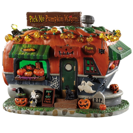 Porcelain lighted building for a Lemax display. Designed to look like a camper made out of a pumpkin. There are carved pumpkins, candles, skulls, spiders, black cats, ghosts and a tombstone. There are lights that are shaped like pumpkins on the roof. There's a sign near the front door that reads "BUY 3 GET ONE FREE!" And a sign on the roof that reads "PICK ME PUMPKIN WAGON."