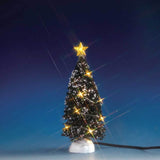 Lemax village accessory designed to look like a snow-covered tree that has yellow lights on it and a yellow star on top.