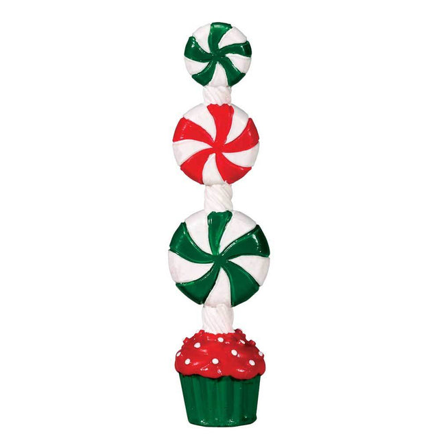 Lemax village accessory designed to look like a small, fake tree made out of desserts. The bottom is a red and green cupcake and there are peppermint candy swirls on top. There are two green and white peppermint candy swirls and one red and white one.