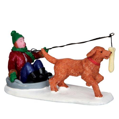 Polyresin figurine for a Lemax display. Designed to look like a young child in a sled. He's taunting the dog in front of him with a bone so the dog will drag the sled.