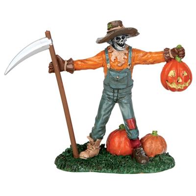 Polyresin figurine for a Lemax display. Designed to look like a scarecrow holding a scythe and a jack-o-lantern. He's wearing a brown floppy hat, an orange shirt and blue overalls with a patch on one knee. There are two pumpkins next to him.