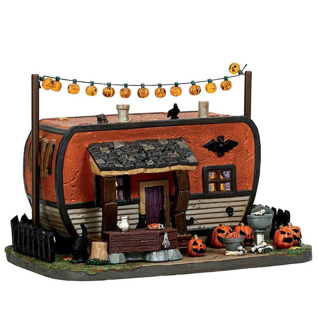 Porcelain accent for a Lemax display. Designed to look like an orange camper van decorated for Halloween. There are pumpkins and bones and orange pumpkin lights.