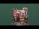 Resin lighted building for a Lemax display. Designed to look like a pizza shop. It's decorated for Christmas and there's snow on the sidewalk. Inside the window, you can see a chef spinning dough in the air. There's a circular pizza sign on the roof.