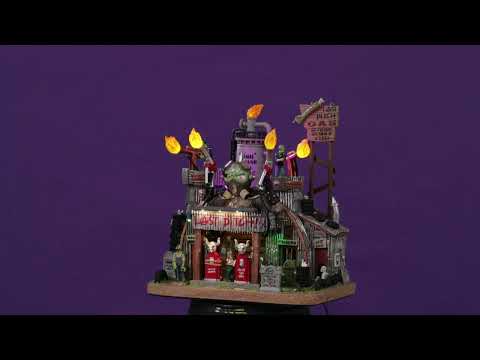Resin lighted building for a Lemax display. Designed to look like a rusty, old gas station. There are monsters working there and tombstones out front. The lights on the roof are actually torches.