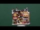 Resin building facade for a Lemax display. Designed to look like a bunch of different store fronts. There's a salon, a hot cocoa booth, a muffin shop and a skate/ski rental shop. It's decorated for Christmas and there's snow on the roof and sidewalk.