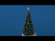 Resin village accent for a Christmas Lemax display. Designed to look like a tall, heavily decorated Christmas tree. There's a lit star at the top and strings of lights. The ornaments are red, green, blue and gold.
