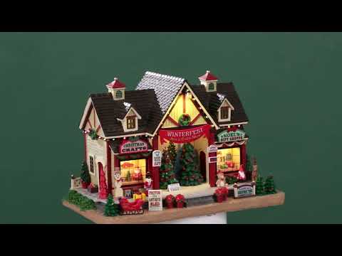 Resin lighted building for a Lemax display. Designed to look like an arts and crafts venue decorated for Christmas. There are decorated Christmas trees on stage for you to vote for your favorite. There's a Christmas crafts shop and a gift shop. There are poinsettia, sleighs, presents, a snowman, a teddy bear, an elf and a reindeer.
